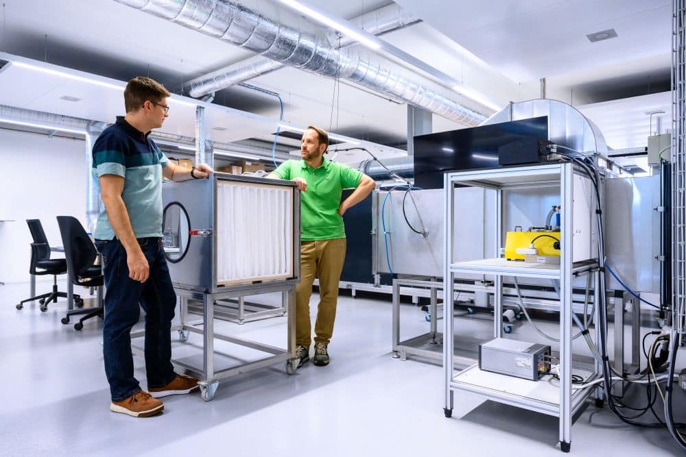 Felix Bots (l.) und Christian Sirtl vor dem Prüfstand für Feinstaubfilter nach ISO 16890 (Bild: Unifil)
