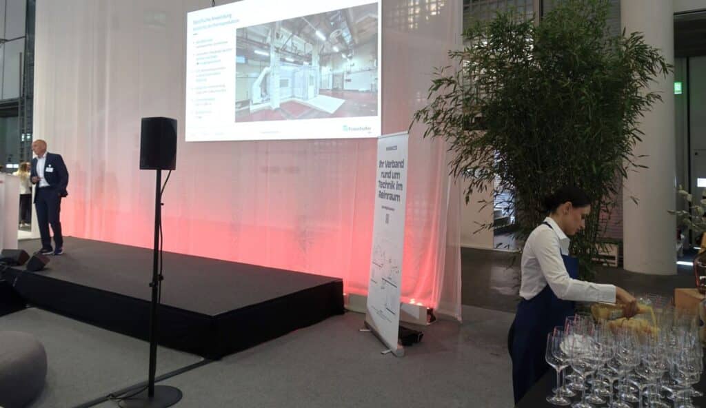 Dr. Udo Gommel, Fraunhofer IPA, stellt die Zukunft der Reinraumtechnik schon heute vor – ein Teil davon: spezifische Anwendungen in der Pharmaproduktion inklusive autoklavierbaren und sterilisierbaren Materialen, verrundeten Übergängen zwischen Wänden und Böden, UVC-Bestrahlungsstrecken, Insekteneintragsschutz, Luftreinheitsklasse ISO 3/GMP A, Reinraum-Aufbauzeit = 2 Tage – und für gleich laufen nebendran schon die Vorbereitungen für den Network-Apéro. (Bild: Ehrensberger)